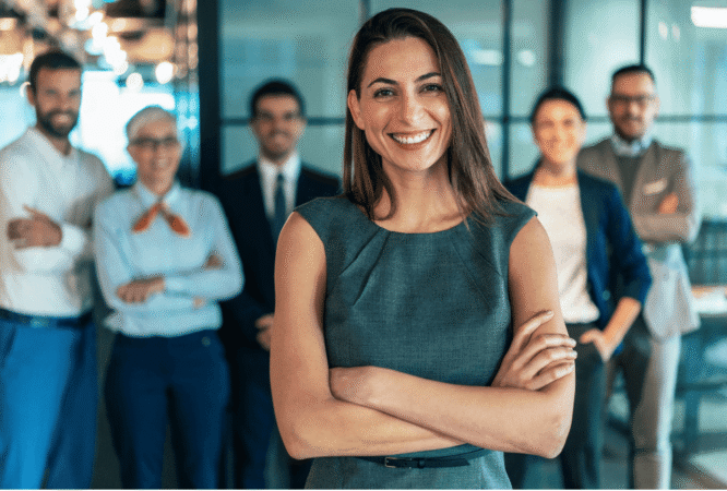 Koçvari liderlik yaklaşımını benimseyen bir liderin; güçlü sorular, aktif dinleme, geri bildirim ve güven ortamı aracılığıyla ekibinin gelişimini ve potansiyelini desteklemesini anlatan kurumsal eğitim görseli.